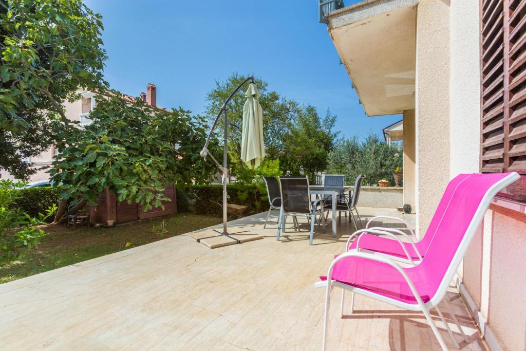 a patio with chairs and a table and an umbrella at Merlini in Medulin