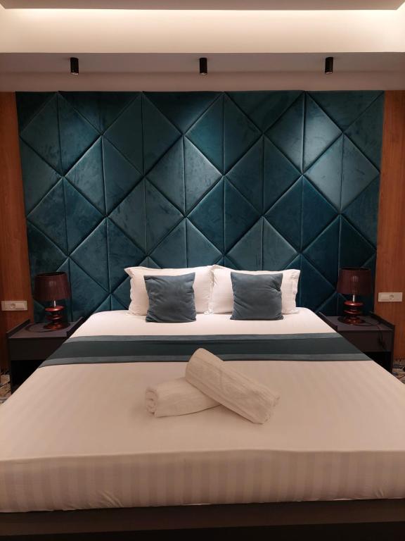 une chambre avec un grand lit et une tête de lit bleue dans l'établissement Apartments Jordan Luxury, à Gevgelija