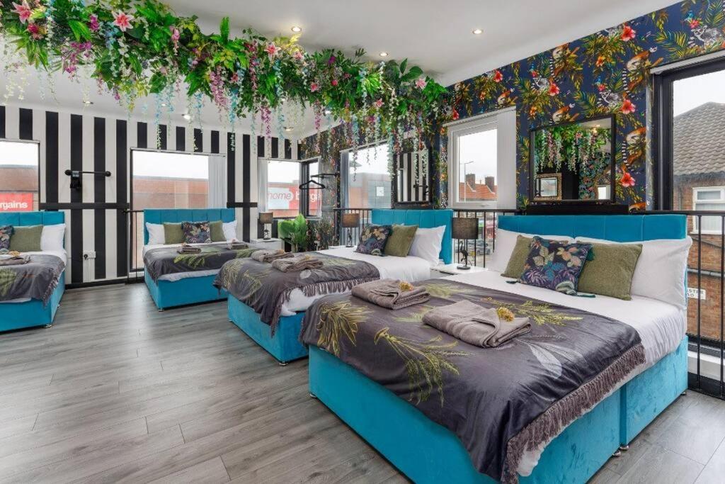 a bedroom with three beds and flowers on the wall at Luxury Mirror Party Pad with 4 Bedrooms! Silent Disco Package included in Liverpool
