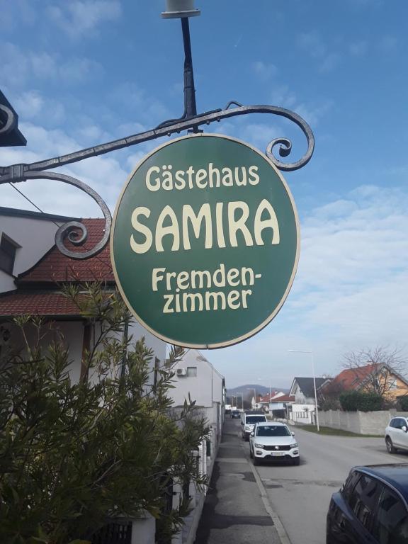a sign for a restaurant with cars parked on a street at Gästehaus Samira in Purbach am Neusiedlersee