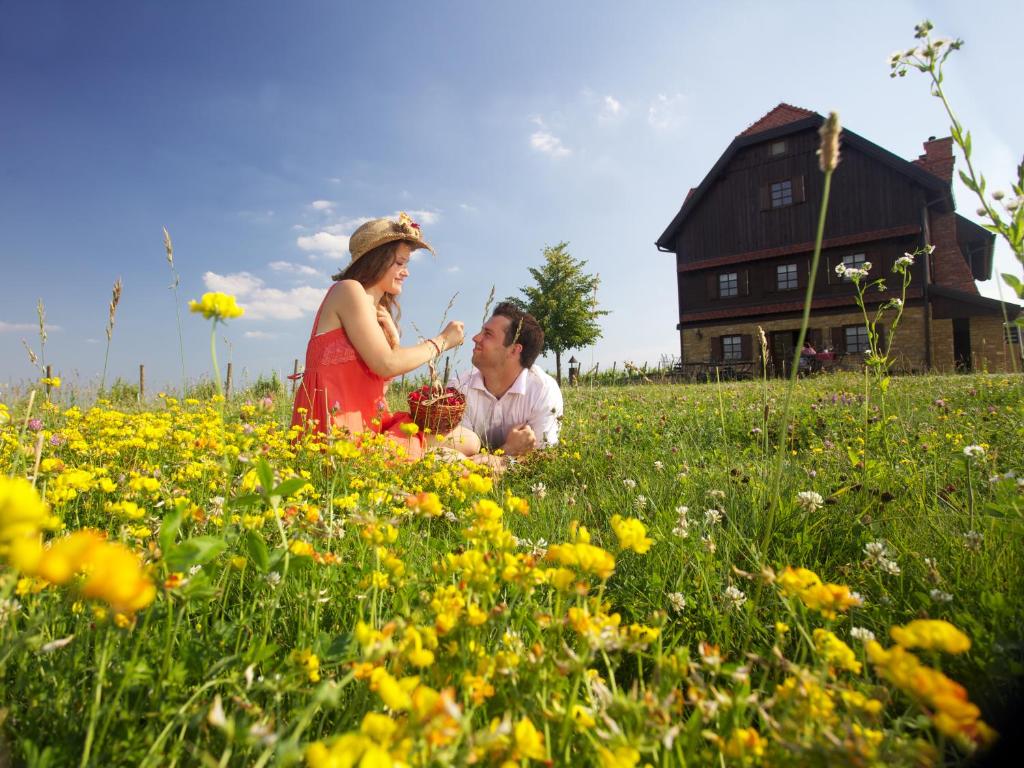 a man and woman sitting in a field of flowers at Rooms Bolfan Vinski Vrh in Hrašćina