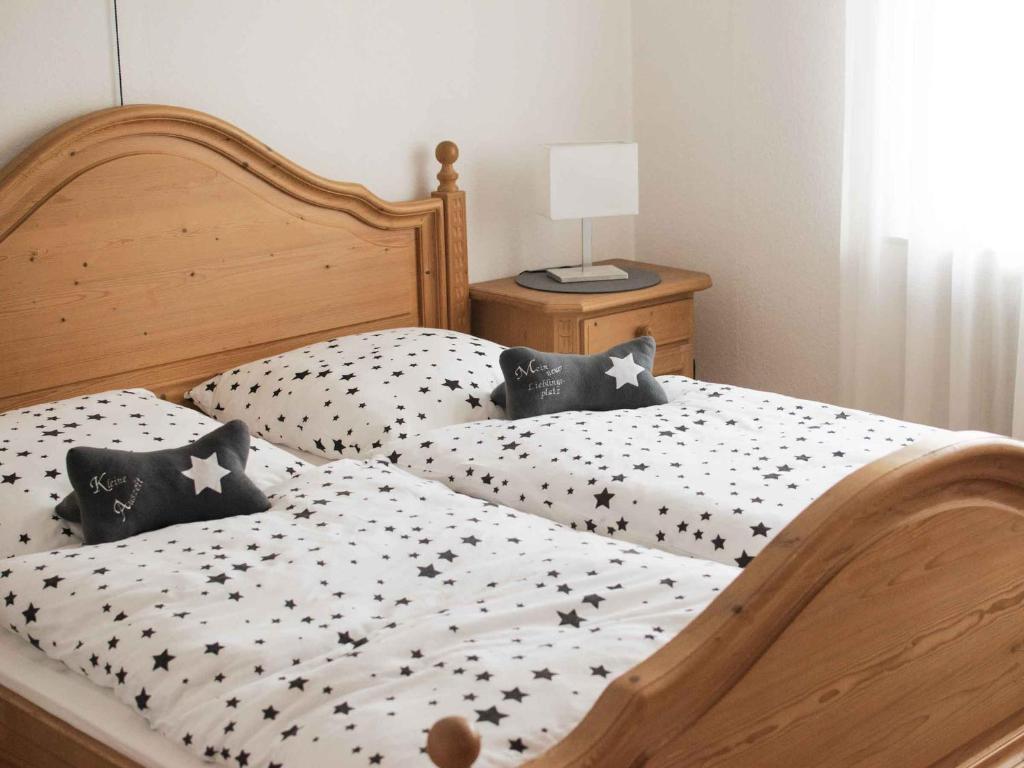 um quarto com 2 camas com lençóis brancos e pretos em Ferienwohnung Annes Stübchen em Schmallenberg