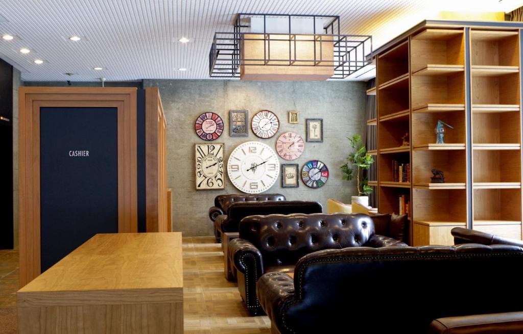 a waiting room with leather chairs and clocks on the wall at HOTEL RELIEF Sapporo Susukino in Sapporo