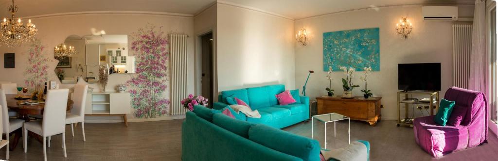 a living room with a blue couch and a dining room at Blue Lake Home in Desenzano del Garda