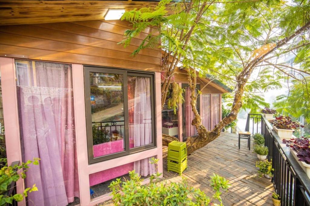 ein Haus mit einer Terrasse mit einem Baum in der Unterkunft Roses Villa Tam Dao - Venuestay in Tam Ðảo