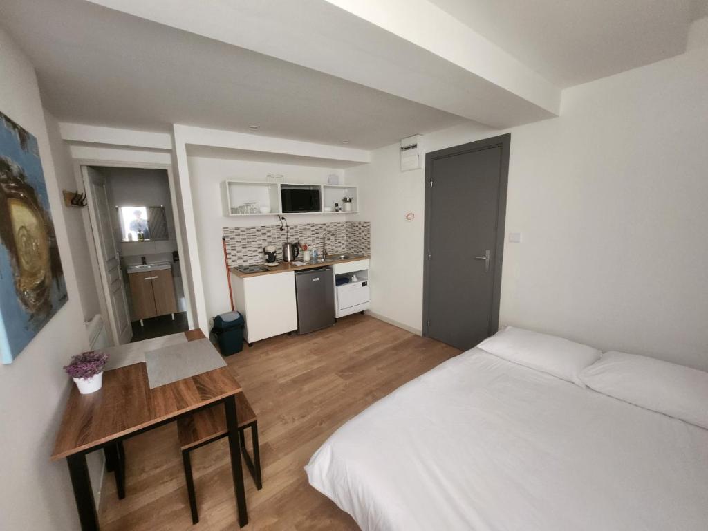 Cet appartement comprend une chambre avec un lit et une table ainsi qu'une cuisine. dans l'établissement Pied à terre tout confort, à Bar-le-Duc