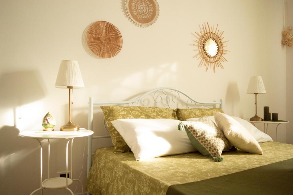 a bedroom with a bed with pillows and a mirror at PURA B&b in Noicattaro