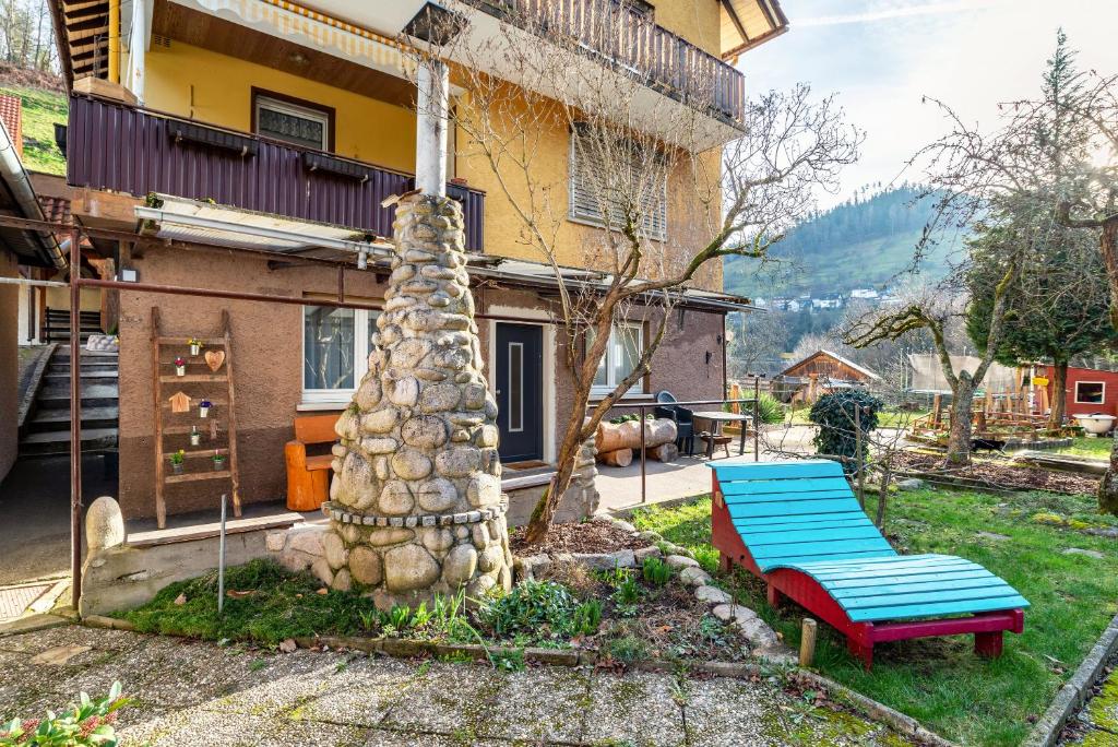 un banc bleu devant une maison dans l'établissement Am Sersbach, à Forbach