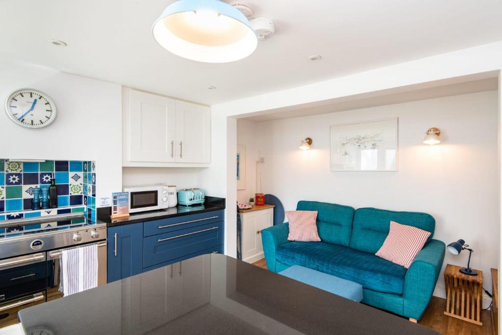 a kitchen with blue cabinets and a blue chair in a kitchen at Quirky 1 Bedroom Apartment in Kemptown in Brighton & Hove
