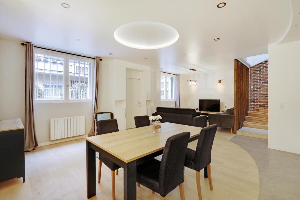 a dining room and living room with a table and chairs at Pick A Flat's Apartment in La Chapelle - Impasse du Curé in Paris