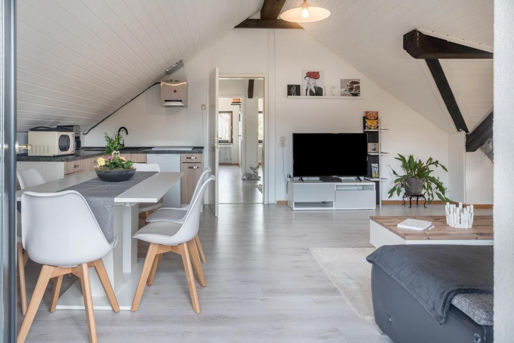 a kitchen and living room with a table and chairs at Ferreira's Loft - Ferienwohnung in St. Blasien
