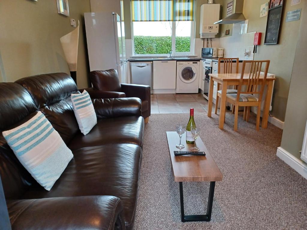 a living room with a leather couch and a table at Solway Retreat in Gretna