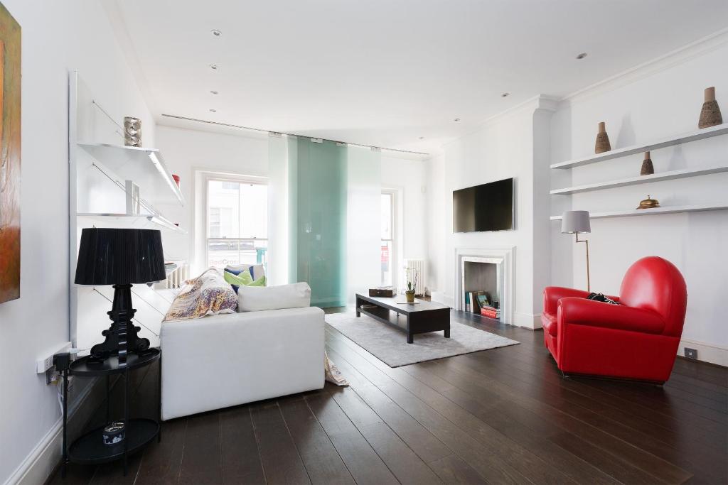 a living room with a couch and a red chair at Stunning flat in Notting Hill with roof top in London