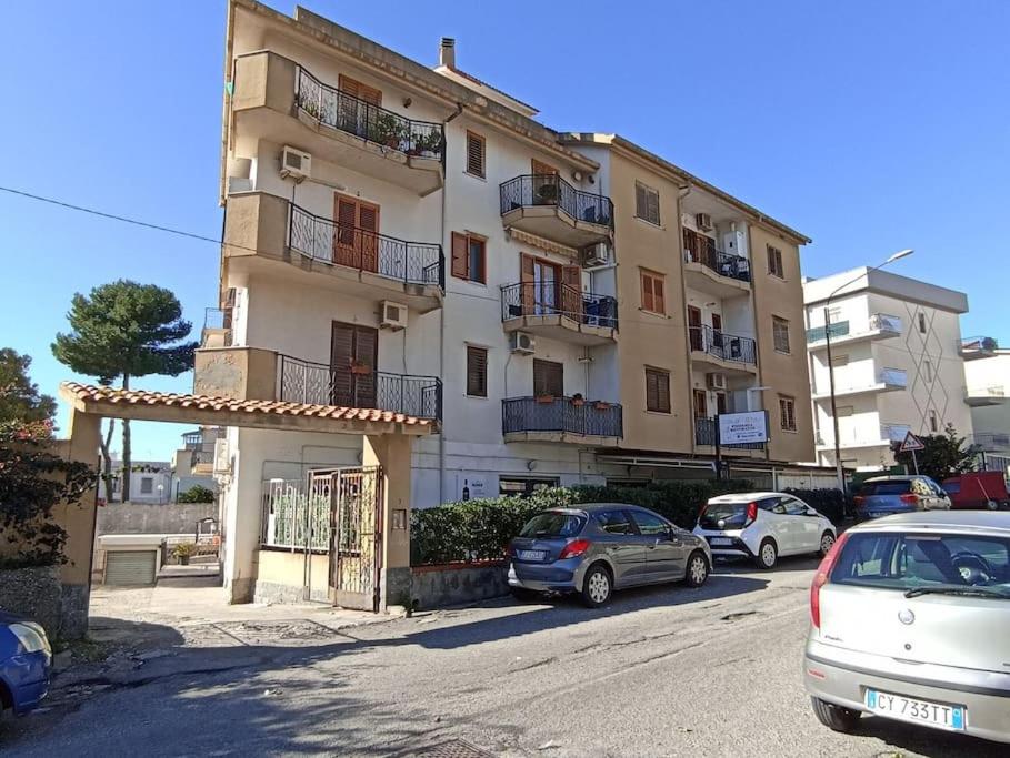 een groot gebouw met auto's geparkeerd voor het bij Appartamento incantevole con parcheggio custodito in Roccella Ionica