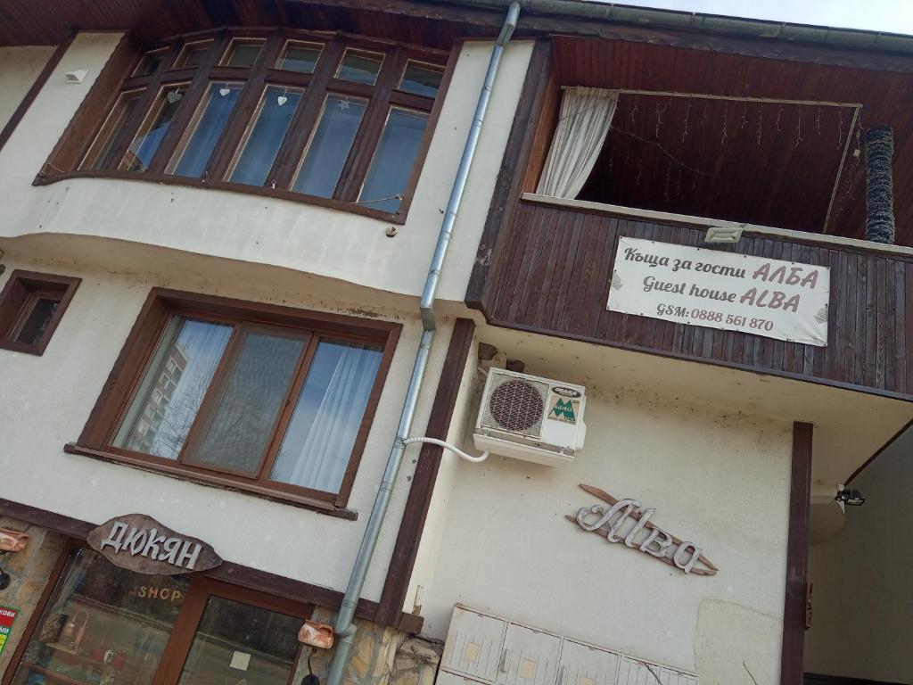 a building with a sign on the side of it at Стаи за гости Алба in Kazanlŭk