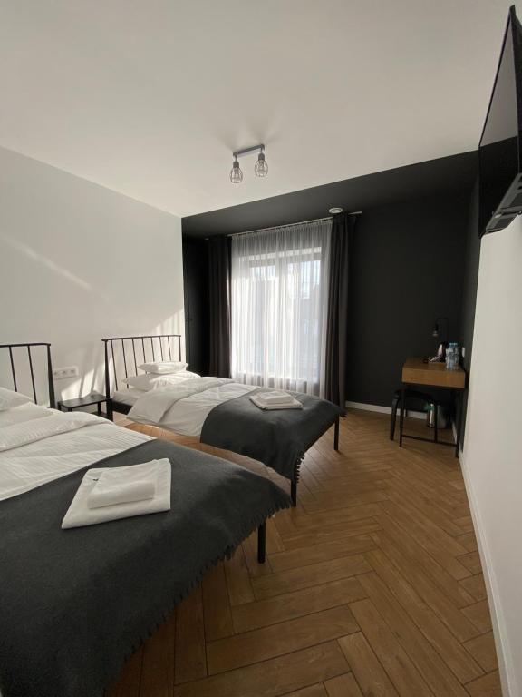 Cette chambre comprend 2 lits et une fenêtre. dans l'établissement Willa K52, à Siemiatycze