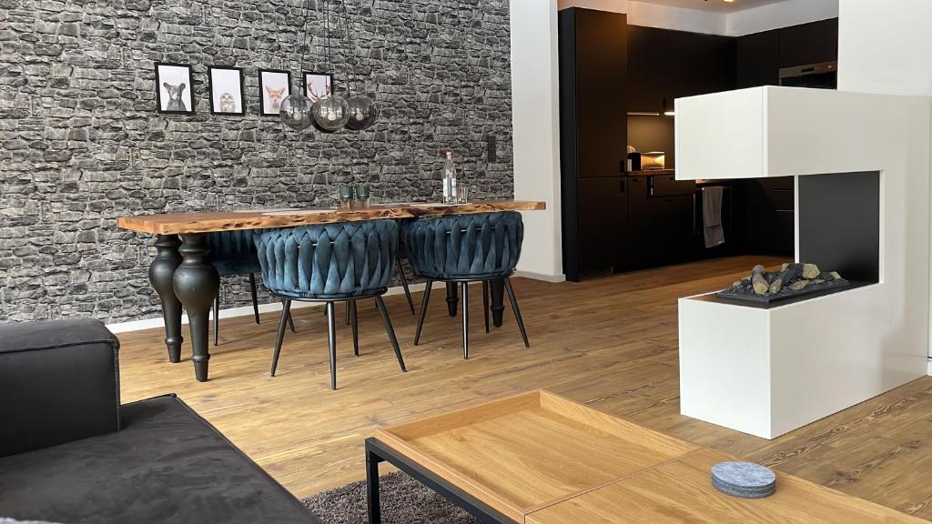 a living room with a wooden table and a brick wall at Fuchs-Fichte in Bad Harzburg