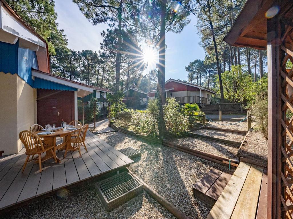 a wooden deck with a table and chairs at Holiday Home Golf Loisirs-1 by Interhome in Lacanau-Océan
