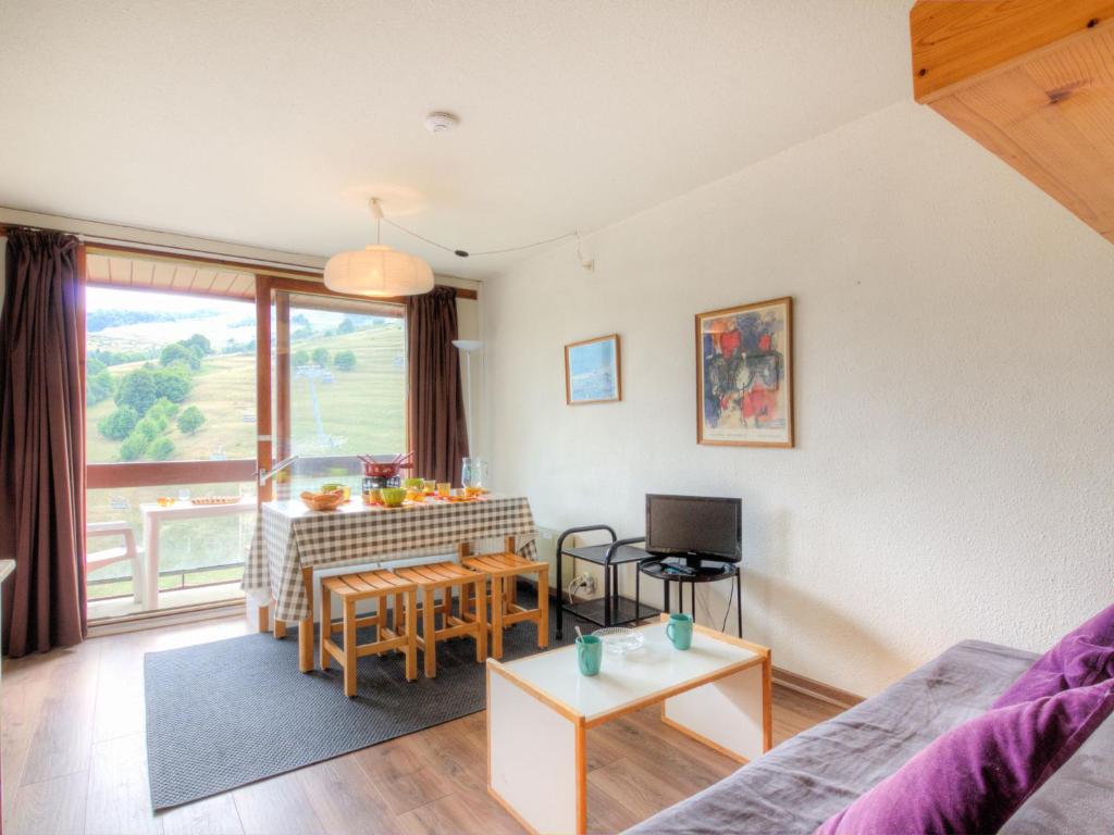 una sala de estar con un sofá y una mesa en Apartment Lunik Orion-22 by Interhome, en Le Corbier