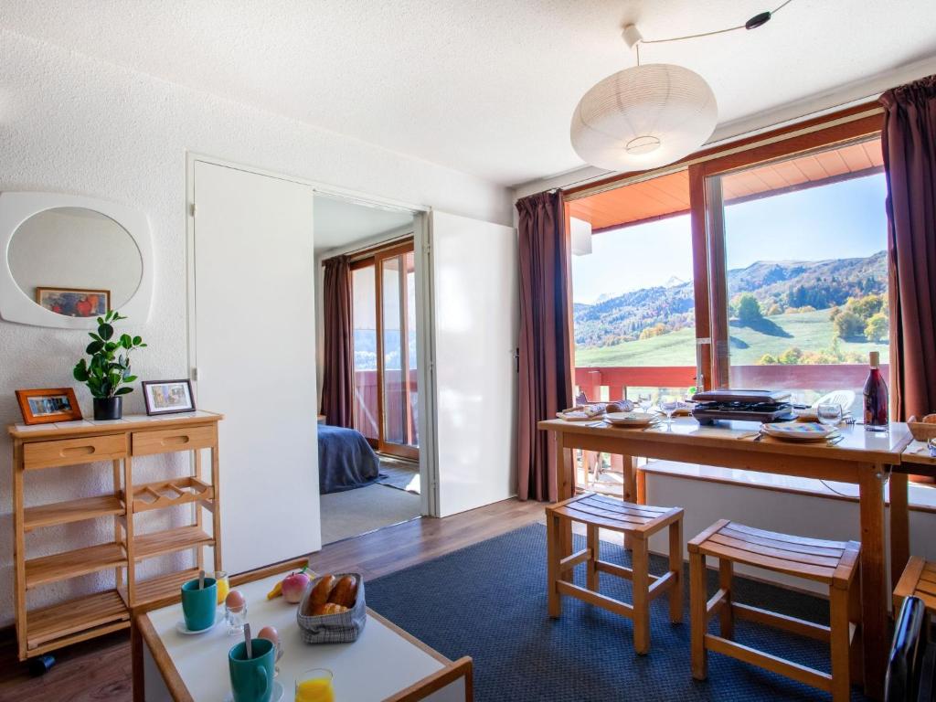 - un salon avec un bureau et une grande fenêtre dans l'établissement Apartment Lunik Orion-22 by Interhome, au Corbier