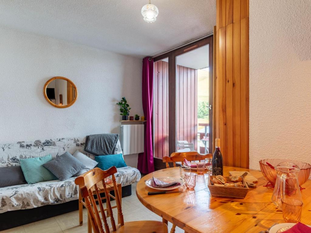 ein Wohnzimmer mit einem Tisch und einem Sofa in der Unterkunft Apartment Les Mousquetons-19 by Interhome in La Toussuire