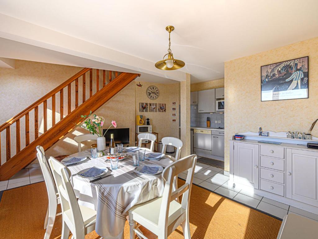a dining room with a table and a kitchen at Apartment Les Villas de Kermaria by Interhome in Kervoz
