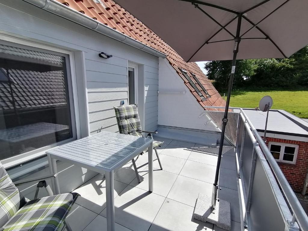 a patio with an umbrella and a table and chairs at May Home in Schashagen