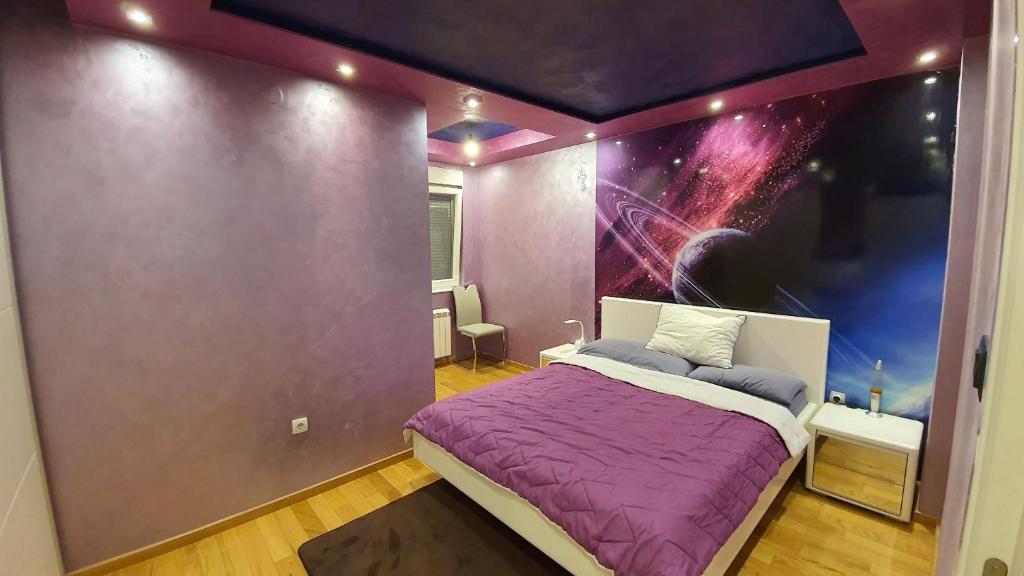 Un dormitorio con una pared morada y una cama. en Urban Home Sweet Home & Parking, en Belgrado