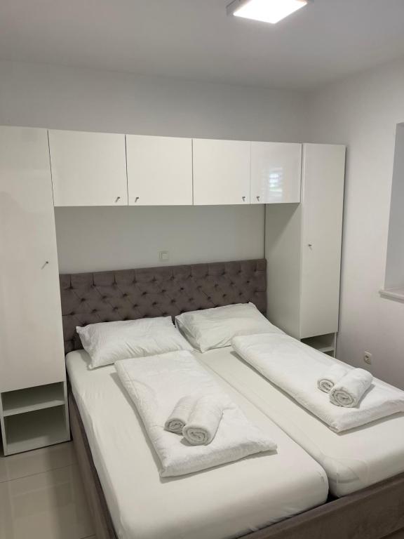 2 Betten in einem weißen Zimmer mit Handtüchern darauf in der Unterkunft Villa San Antonio-exclusive apartments in Baška