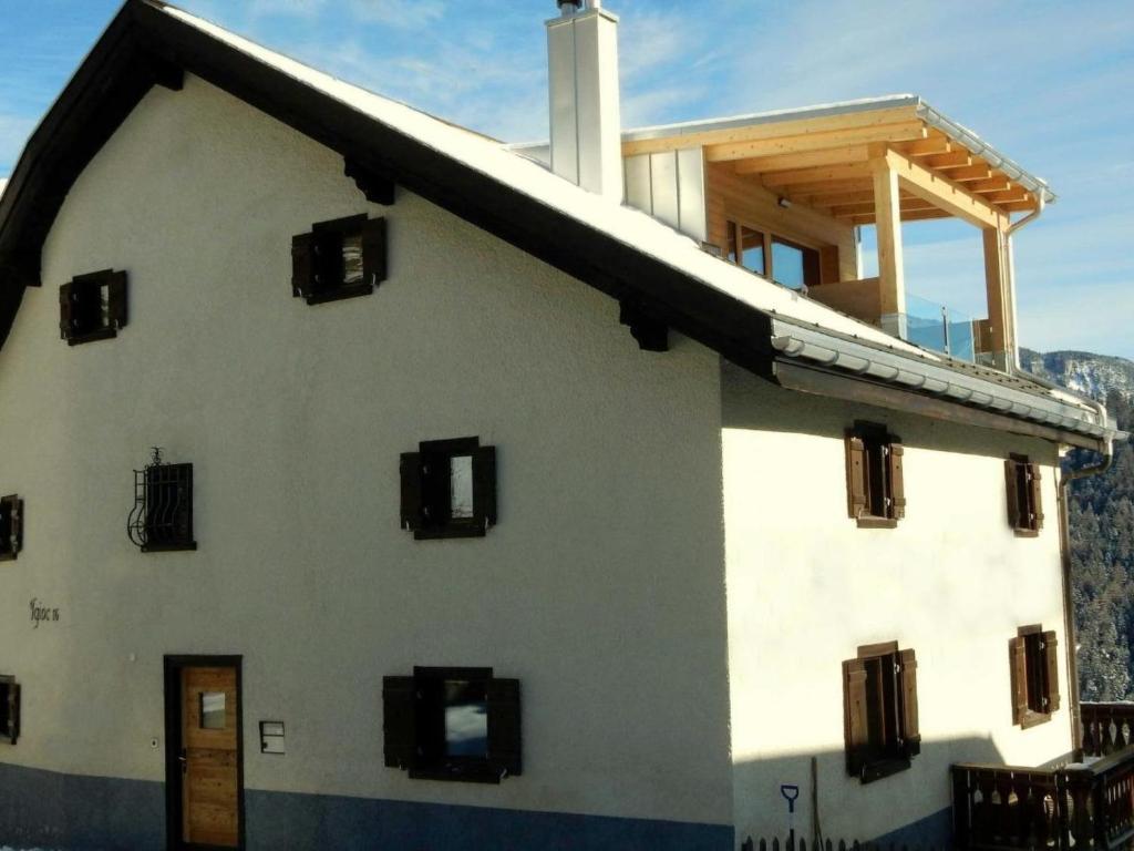 Apartment Ferienhaus Tgioc by Interhome في Obervaz: مبنى ابيض كبير نوافذه جانبيه