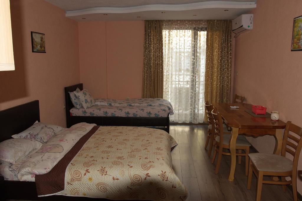 a bedroom with a bed and a table and a desk at Studio Manushev in Sandanski