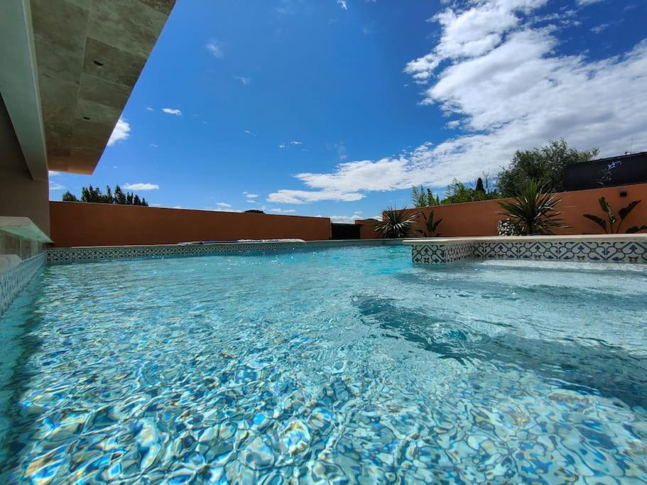 une grande piscine avec un ciel bleu en arrière-plan dans l'établissement La Villa Nina, à Mirepeisset