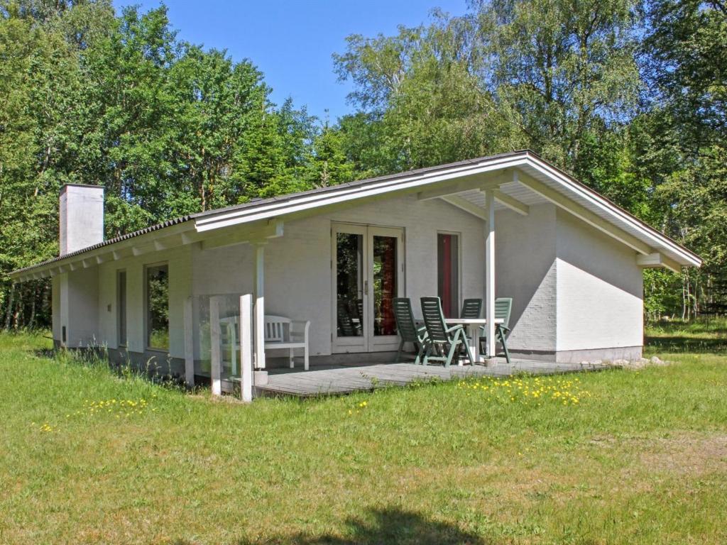 a small white house with a porch and chairs at Holiday Home Gerarda - 4km from the sea in NE Jutland by Interhome in Læsø