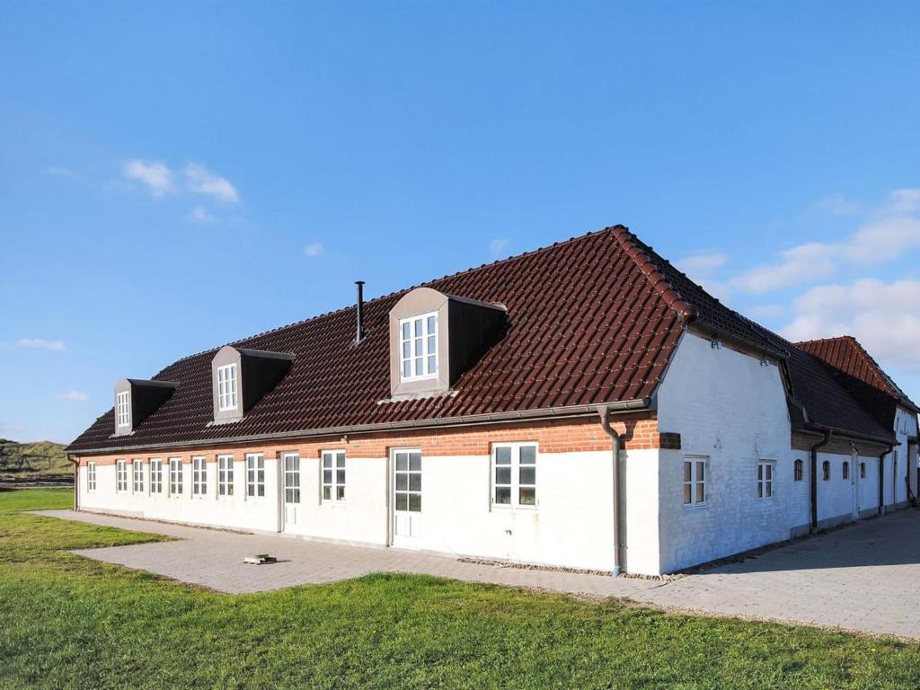 ein großes weißes Gebäude mit braunem Dach in der Unterkunft Holiday Home Erik - 300m from the sea in Western Jutland by Interhome in Hvide Sande