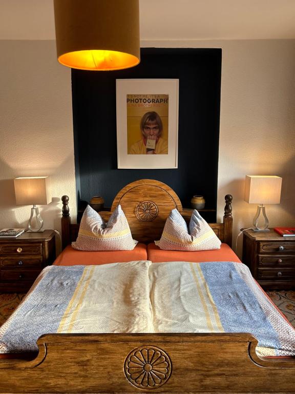 ein Schlafzimmer mit einem großen Holzbett mit zwei Nachttischen in der Unterkunft Buntes Haus in Erfurt