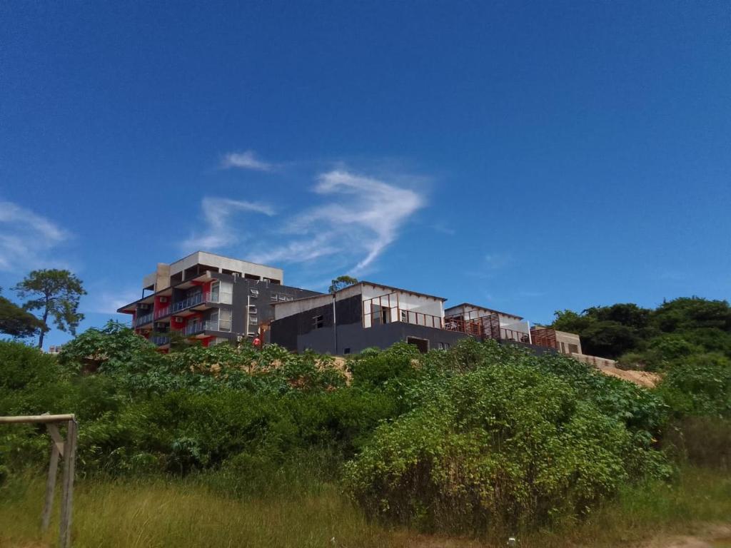 a building sitting on top of a hill with grass at Onothweni Lodge in Manguzi