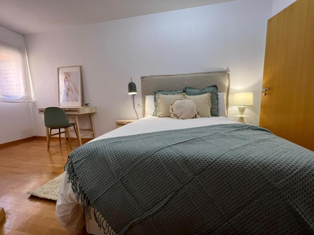 a bedroom with a large bed and a desk at Apartamento Playa Delicias in Águilas