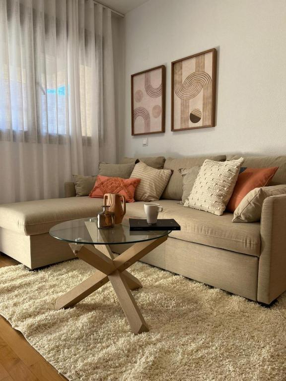 a living room with a couch and a glass table at Apartamento Playa Delicias in Águilas