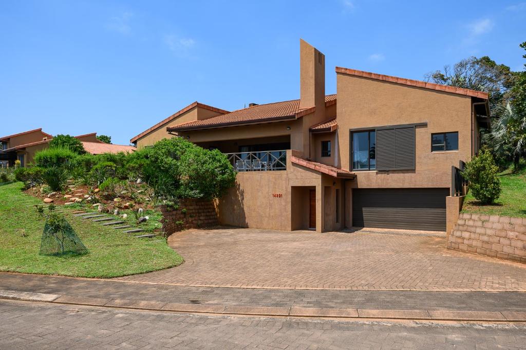 ein Haus mit einer Auffahrt davor in der Unterkunft San Lameer Villa 14321 - 5 Bedroom Deluxe - 10 pax - San Lameer Rental Agency in Southbroom