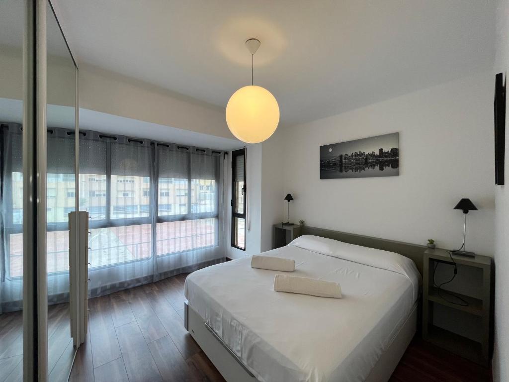 a bedroom with a large bed and a large window at August centro Tarragona in Tarragona