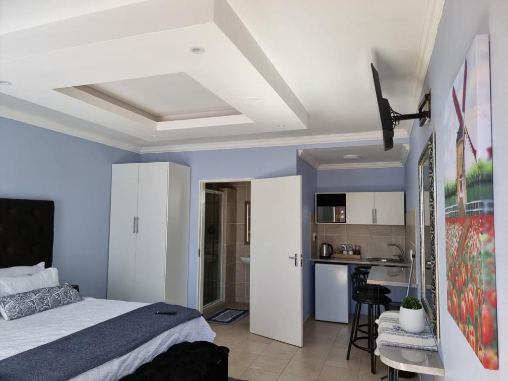 1 Schlafzimmer mit einem Bett und einer Küche in der Unterkunft Danrit Guesthouse - Uncapped wifi in Roodepoort