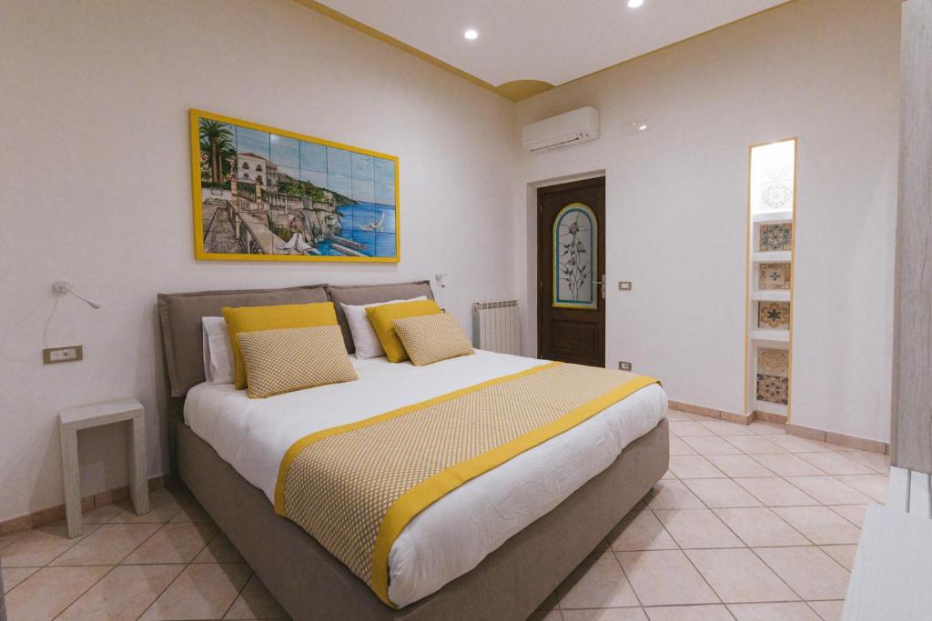 una camera da letto con un grande letto con cuscini gialli di Casa La Bifora a Sorrento