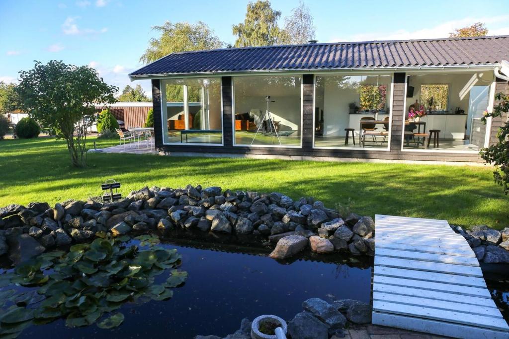 a house with a pond in the yard at The comfort of this cottage merges with nature in Holbæk