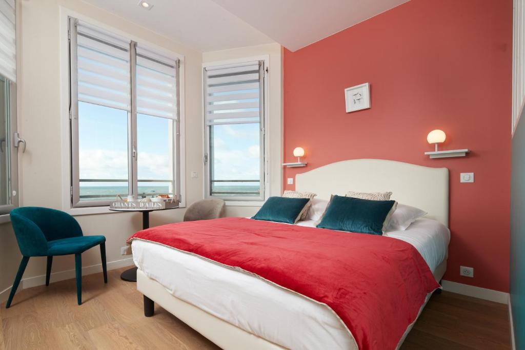 - une chambre rouge avec un lit avec un mur rouge dans l'établissement Les Chants d'Ailes - Hôtel Face Mer, à La Turballe