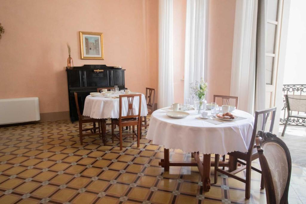 a dining room with two tables and chairs at Palazzo Zacà in Gallipoli