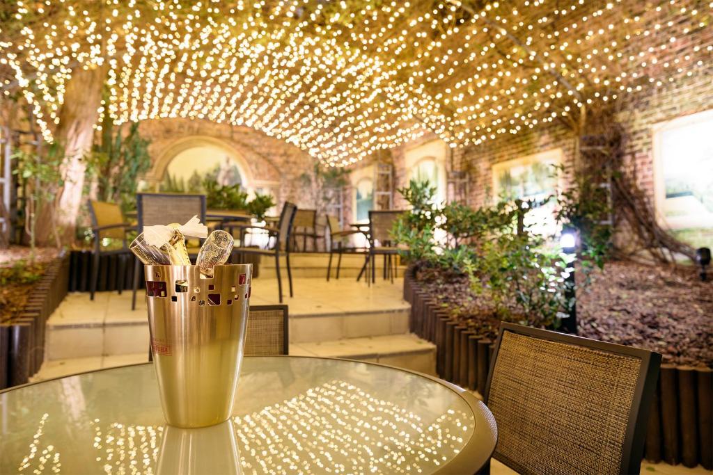 a glass vase sitting on a table in a room with lights at Hotel Le Châtelain in Brussels