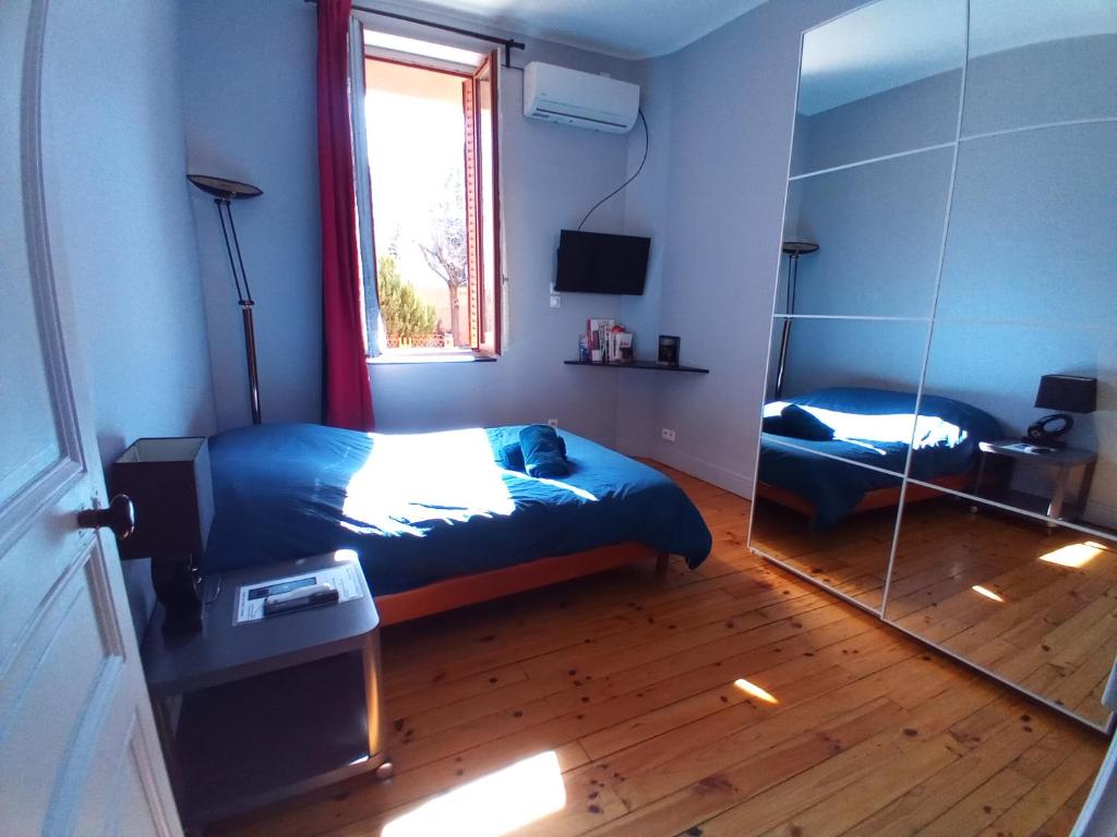 een slaapkamer met een spiegel, een bed en een raam bij Appart-Hotel Métro D Mermoz Lyon8 in Lyon