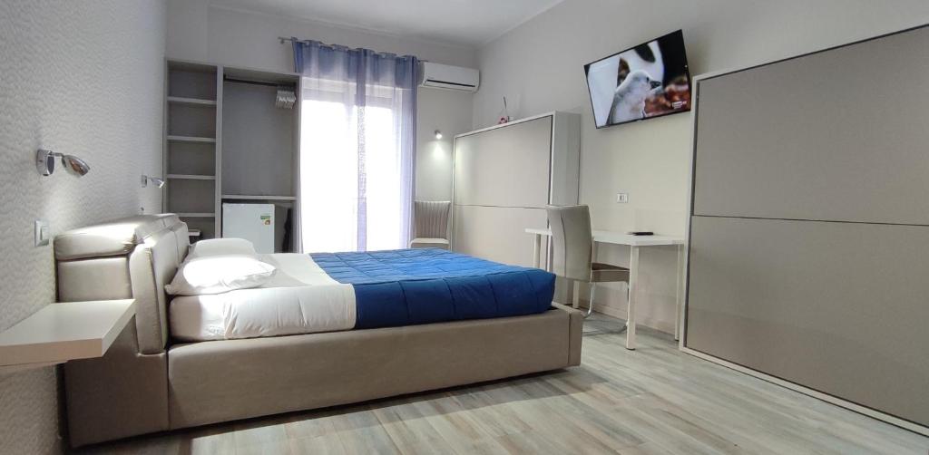 Schlafzimmer mit einem Bett, einem Schreibtisch und einem Fenster in der Unterkunft Nitto House in Bari