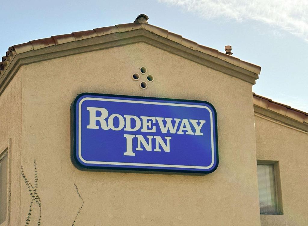 un panneau bleu sur le côté d'un bâtiment dans l'établissement Rodeway Inn South Gate - Los Angeles South, à South Gate