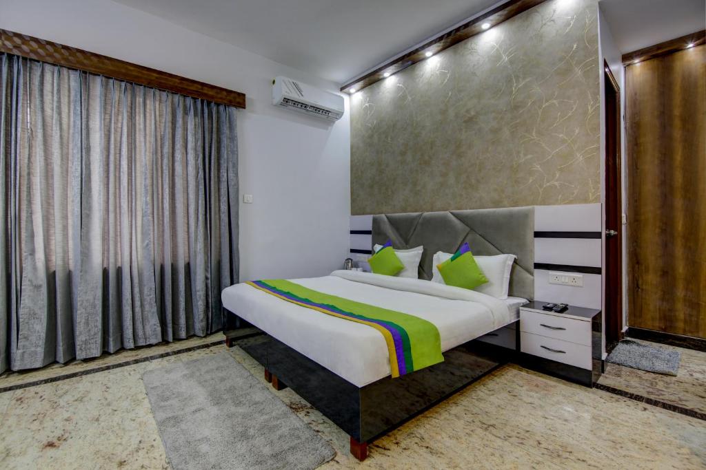 a bedroom with a bed and a large window at Treebo Trend Sai Village Manesar in Gurgaon